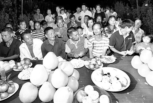 江西吉水县白水垦殖场井冈蜜柚园里,柚农在品柚子吃月饼庆贺丰收。盛产期的井冈蜜柚每亩经济效益可达2万元以上,是当地民众的致富果。廖敏 摄